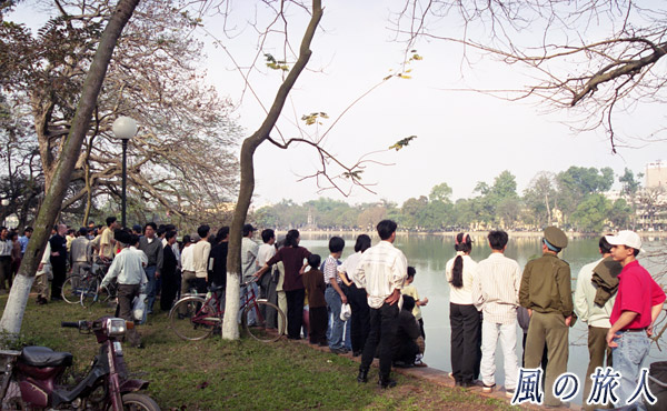ベトナム　ハノイ　ホアンキエム湖　池を見つめる人々の写真