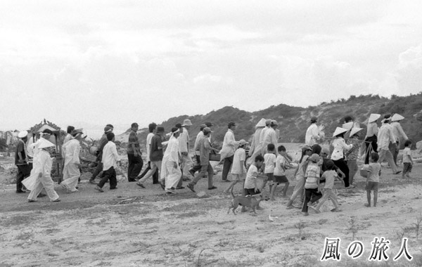 ベトナム　ムイネ　葬式行列に付いていくワンコの写真