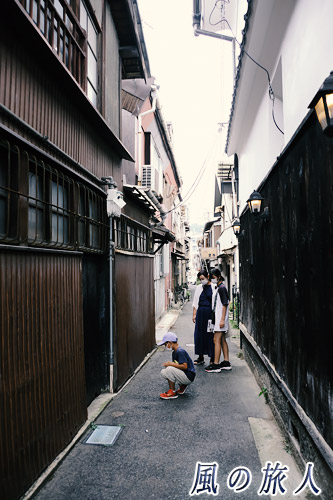 尾道　路地で猫を探す子供たちの写真