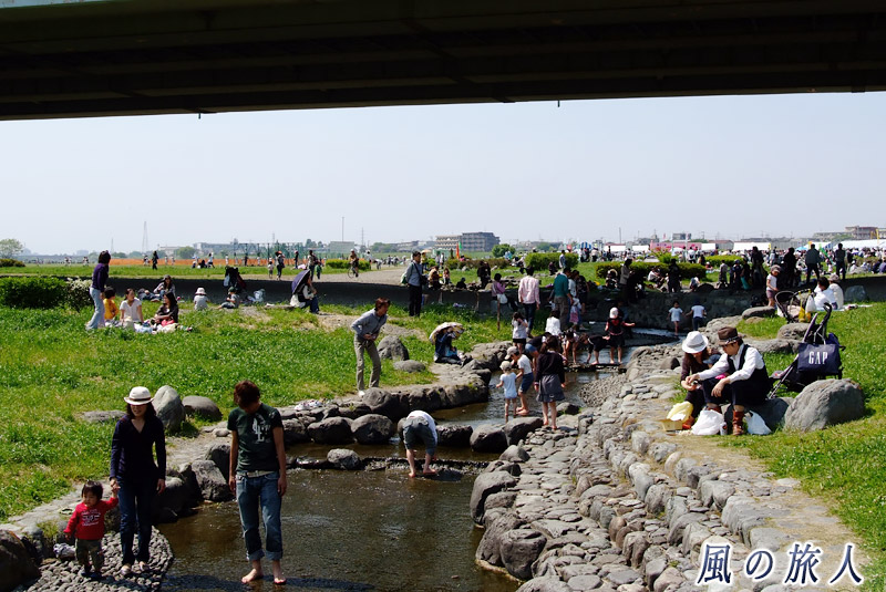 二子玉川兵庫島公園　せせらぎで遊ぶ人々の写真