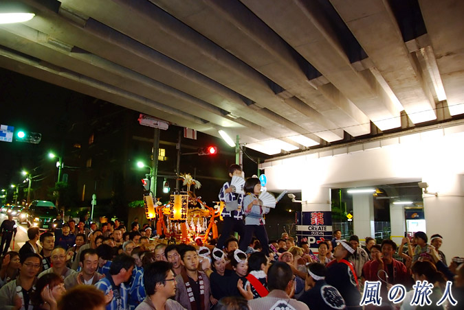 経堂天祖神社の神輿渡御　2012年宮入り　小田急線高架下を進む様子の写真