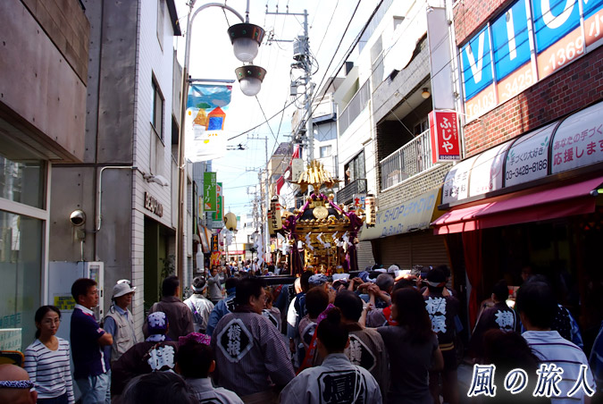 稲荷森稲荷神社の神輿渡御　2012年の宵宮宮出し　商店街を進んでいく神輿の写真
