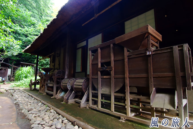 岡本民家園　軒下に置かれた農機具の写真